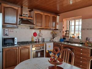 a kitchen with wooden cabinets and a table in it at O Chalé das Borboletas in Santa Maria Madalena