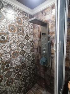 a shower with a wall covered in tiles at Appartement très calme a 10 mn de mehdia in Kenitra +16 photos
