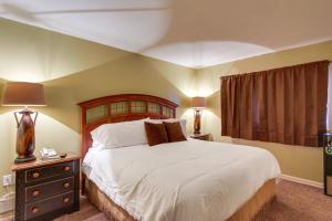 a bedroom with a large bed with a wooden headboard at Bear-Sighting Condo Walk to Downtown Gatlinburg! in Gatlinburg +16 photos
