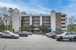a parking lot with cars parked in front of a building at Bear-Sighting Condo Walk to Downtown Gatlinburg! in Gatlinburg
