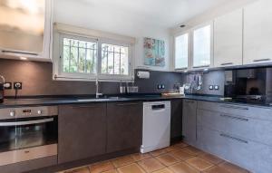 a large kitchen with stainless steel appliances and windows at Beautiful Home In Mougins in Mougins