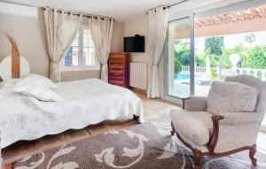 a bedroom with a bed and a chair and a window at Beautiful Home In Mougins in Mougins