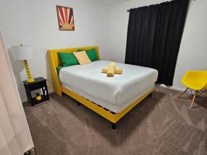 a bedroom with a bed with green and yellow pillows at Gorgeous Home, Great Vibes & Nonstop Fun! in Desert Hot Springs