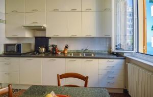 a kitchen with white cabinets and a sink and a table at 4 Bedroom Lovely Apartment In Camogli in Camogli