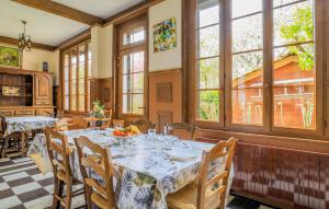 a dining room with a table and chairs and windows at Beautiful Home In Le Crotoy With Wifi in Le Crotoy