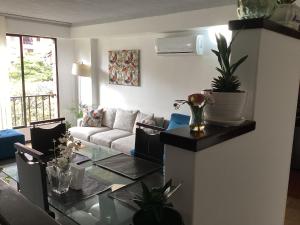 a living room with a couch and a glass table at Riberas apt, unique & memorable in Cali
