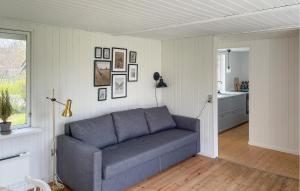 a living room with a blue couch and a kitchen at 2 Bedroom Lovely Home In Dannemare in Dannemare