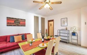 a living room with a table and a red couch at 1 Bedroom Lovely Apartment In Grado in Grado +14 photos