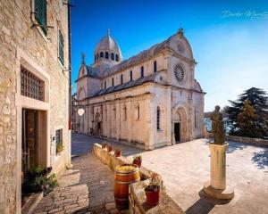 シベニクにあるLana Šibenikの時計塔のある古い石造りの建物