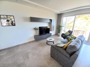 un soggiorno con un divano e una TV di Yellow Hill Penthouse a Żebbuġ