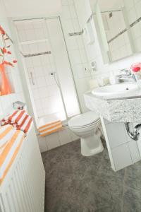 a white bathroom with a toilet and a sink at Kocks Hotel Garni in Hamburg