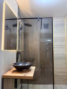 un baño con una ducha de cristal con un bol sobre una mesa en Sunset LOFT Mangalia, en Mangalia 19 fotos más