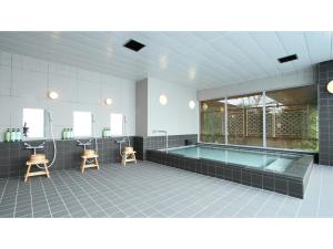 a large bathroom with a tub and two stools at Hotel AreaOne Chitose - Vacation STAY 96118v in Chitose