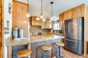 a kitchen with wooden cabinets and a stainless steel refrigerator at Wills Place Utah Family Getaway Hot Tub and Yard in Glendale