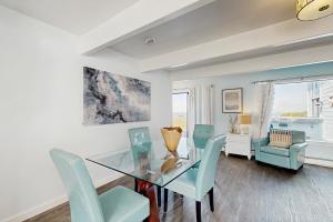 a dining room with a glass table and blue chairs at Stella Del Mare in Fort Bragg +12 photos