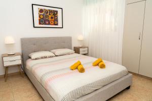 a bedroom with a bed with yellow pillows on it at Olivia Mackenzie 2 Bedroom Flat with Pool in Larnaka +21 photos