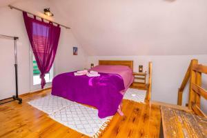 a bedroom with a bed with a purple blanket at House Moj mir in Primošten