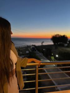 a woman looking out at the ocean at sunset at Villa Kyma by the sea, in South Crete in Keratokampos