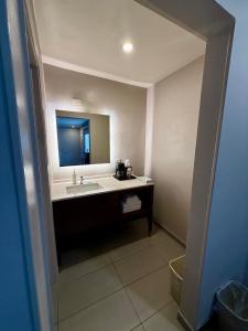 a bathroom with a sink and a mirror at Heritage Inn San Diego in San Diego