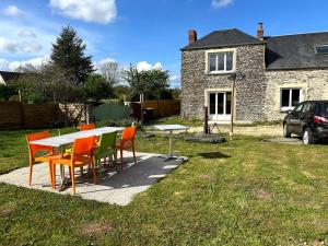 a table and chairs in front of a house at Le relais de Noron in Noron-la-Poterie