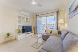 Una sala de estar con un sofá y un televisor. en Beautiful sea view apartment with air condition San Remo-Palm Mar Arona, en Palm-mar