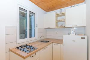 a kitchen with a stove and a white refrigerator at House ULE in Žrnovo