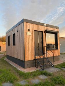 a tiny house with a staircase in a yard at Tiny House Boddenblick - Ostsee in Groß Kordshagen