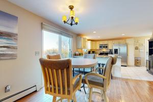 Una cocina y un comedor con mesa y sillas. en Oak Ridge Retreat, en Sagamore Beach
