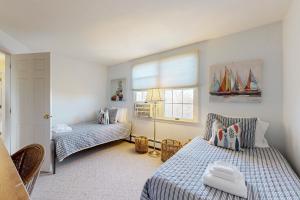 Un dormitorio con dos camas y una ventana. en Oak Ridge Retreat, en Sagamore Beach
