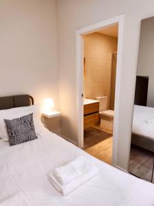 une chambre avec un lit blanc et une salle de bain dans l'établissement Esmeralda Suites 1, à Santa Cruz de Tenerife