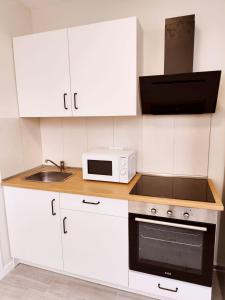 - une cuisine blanche avec un four micro-ondes et un évier dans l'établissement Esmeralda Suites 1, à Santa Cruz de Tenerife