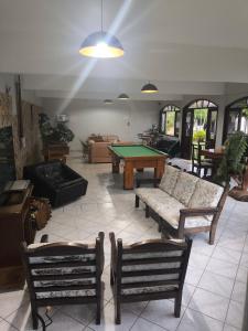 a living room with couches and a pool table at POUSADA NOSSA SENHORA in Penedo