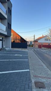 an empty street next to a building and a building at City Nest Apartament in Rădăuţi