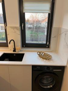 a kitchen with a washing machine and a window at City Nest Apartament in Rădăuţi +61 photos