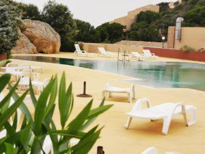 a pool with white lounge chairs and a swimming pool at Wild Paradise in Costa Paradiso
