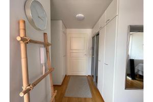 a hallway with a clock on the wall and a mirror at Kotiyksiö Vaughan in Lahti
