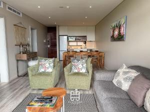 a living room with a couch and two chairs at Zimbali Suites Ocean View Nyambose Villas in Ballito