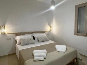 Un dormitorio blanco con una cama con toallas. en Villa Virò by salentoltremare, en Alessano