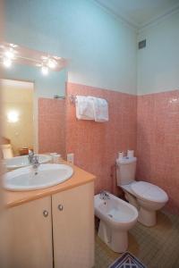 a bathroom with a sink and a toilet at Hôtel Saint Vincent in Bagnères-de-Bigorre