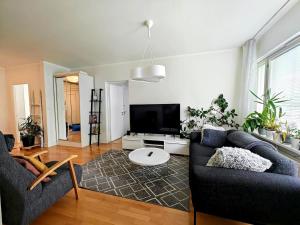 a living room with a couch and a tv at Spacious and bright 2 bedroom apartment in Oulu