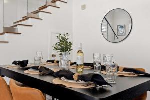 Una mesa negra con una botella de vino y un espejo. en New Listing Dodger Clubhouse by Colby & Conrad, en Los Ángeles