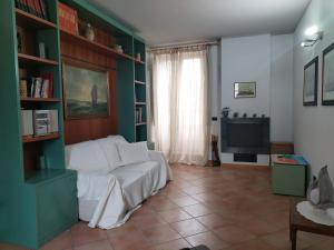 a living room with a couch and a television at Casa Vacanza Sole terrazza in Ameglia