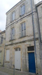 ラ・ロシェルにあるL'Atelierの青い扉のある古い石造りの建物