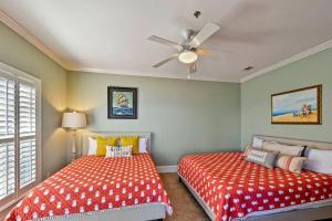 ein Schlafzimmer mit zwei Betten und einem Deckenventilator in der Unterkunft Garden Cottage 07 in Jekyll Island + 42 Fotos
