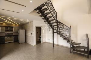 a spiral staircase in a room with a kitchen at Yaras villa in Ash Shāghūr