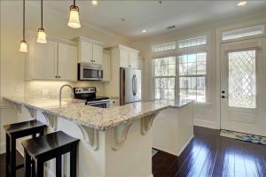 a kitchen with white cabinets and a large counter top at Garden Cottage 09 in Jekyll Island