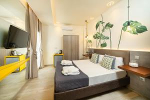 a bedroom with a bed and a flat screen tv at Ester Luxury Rooms in Skala Potamias