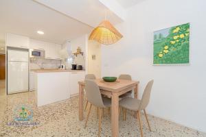 eine Küche und ein Esszimmer mit einem Holztisch und Stühlen in der Unterkunft 2 bed 2 bath Magnus Apartment in El Campello