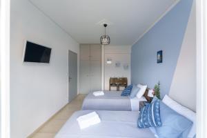 a hotel room with two beds and a couch at S K apartments K in Argostoli