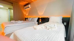 two beds with white sheets in a room at Setai Yacht Premium - By Almare Flats in João Pessoa